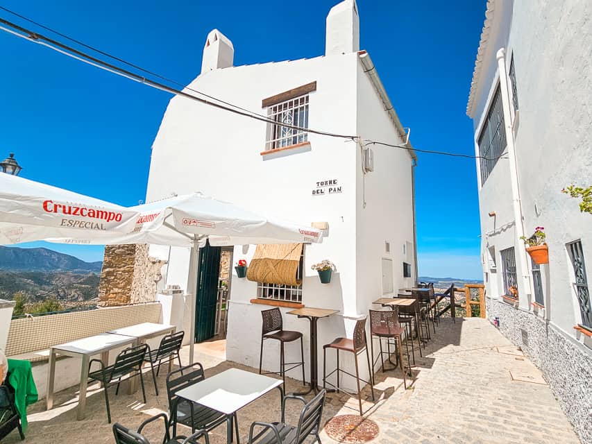 White building with tables and chairs.