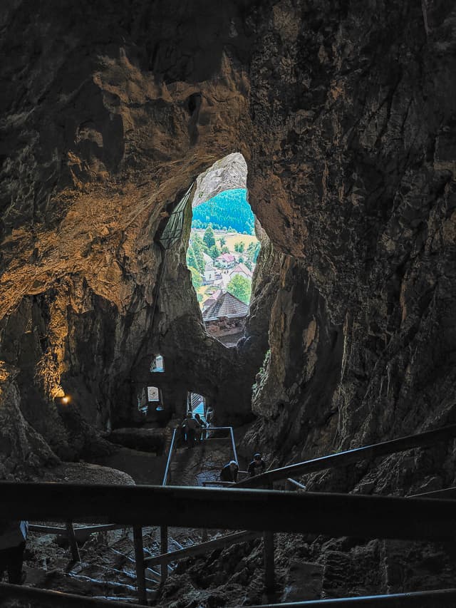 A stone staircase from the cave going to the stone castle that connects to it by bridge.