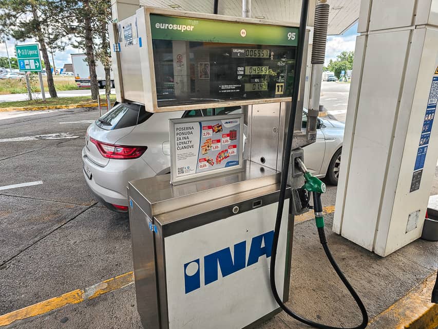 Gas pump with car in background in Slovenia.