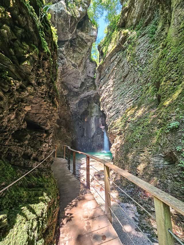 A wooden boardwalk continues around the rock wall where you can see the gorgeous Kozjak waterfall with its crystal clear turquoise water.