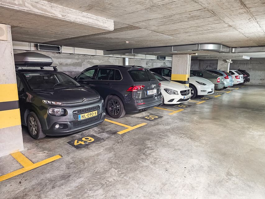 Cars are parked in a line in a parking garage.