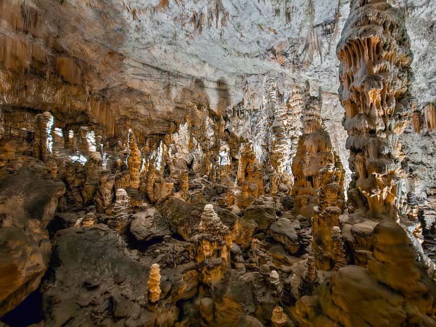 A massive cave cavern in the Postojina cave with stalagmites and stalactites covering the cavern.
