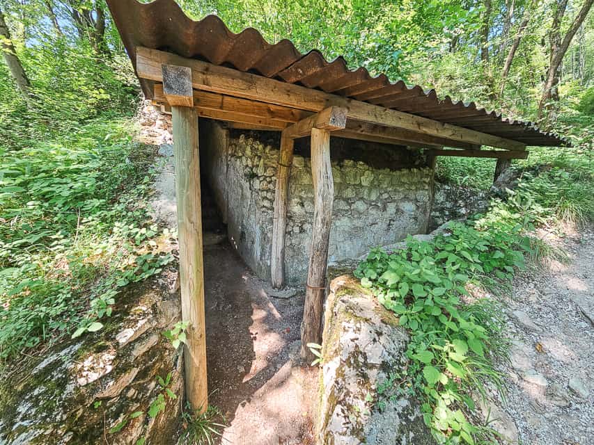 A stone WWI bunker with a metal roof and a stone middle.