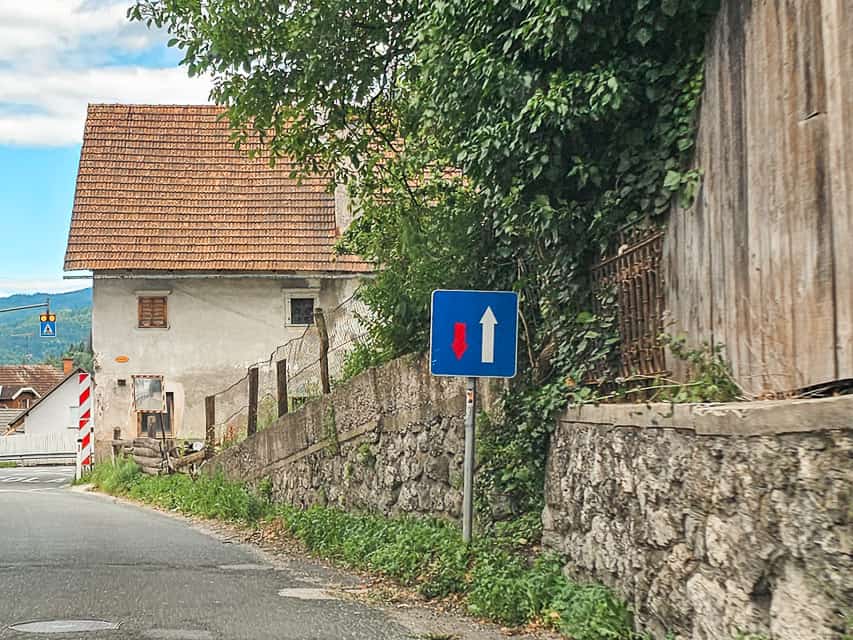 A blue sign with arrows that indicates right of way.