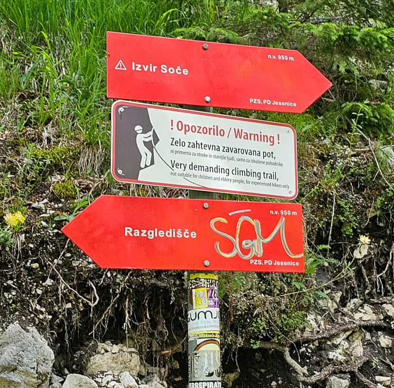 Red signs pointing to different hikes and warning you of the trail conditions.