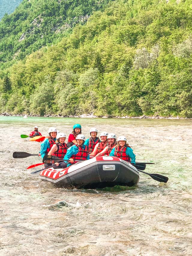 A group of people on a raft go down the Soča River which is one of the best things to do in Slovenia,