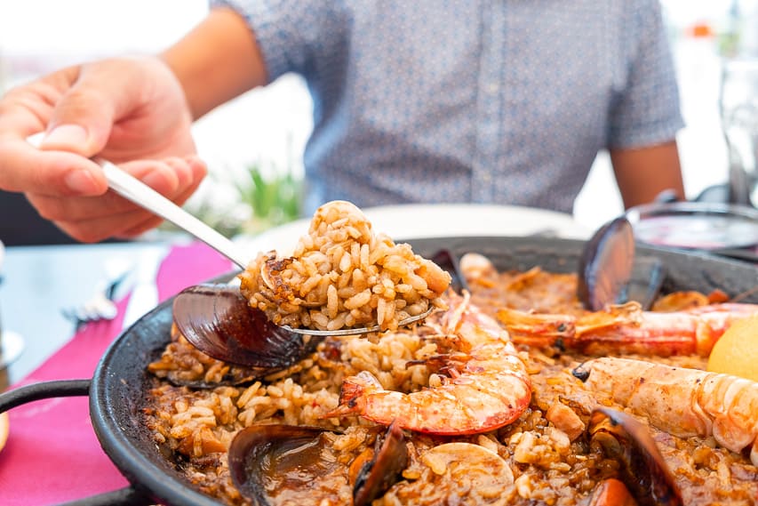 A spanish dish with curry and rice with shrimp and clams.