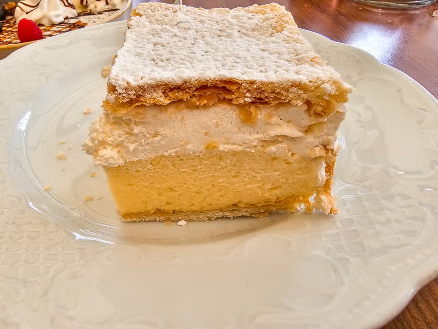 A flaky dark gold pastry with a custard and sponge cake layered under and finished off with powered sugar.