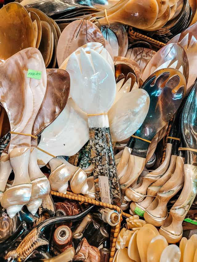Shell spoons with lots of pieces of shell on the handle and a light colored spoon itself.