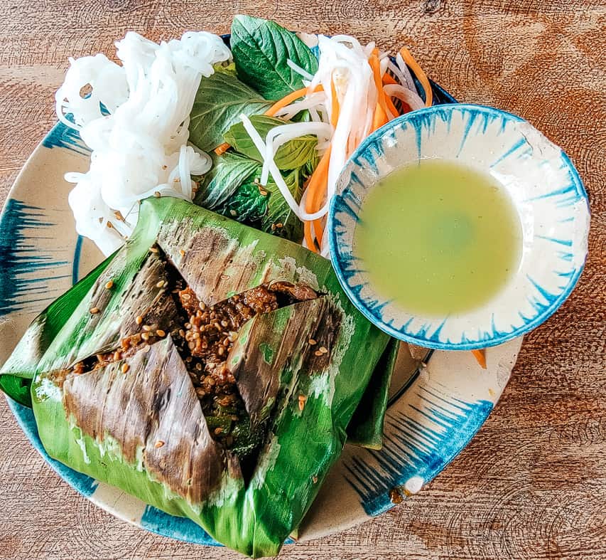 A beautifully plated lunch with vegetables and lettuce wrapped seeds and meat.