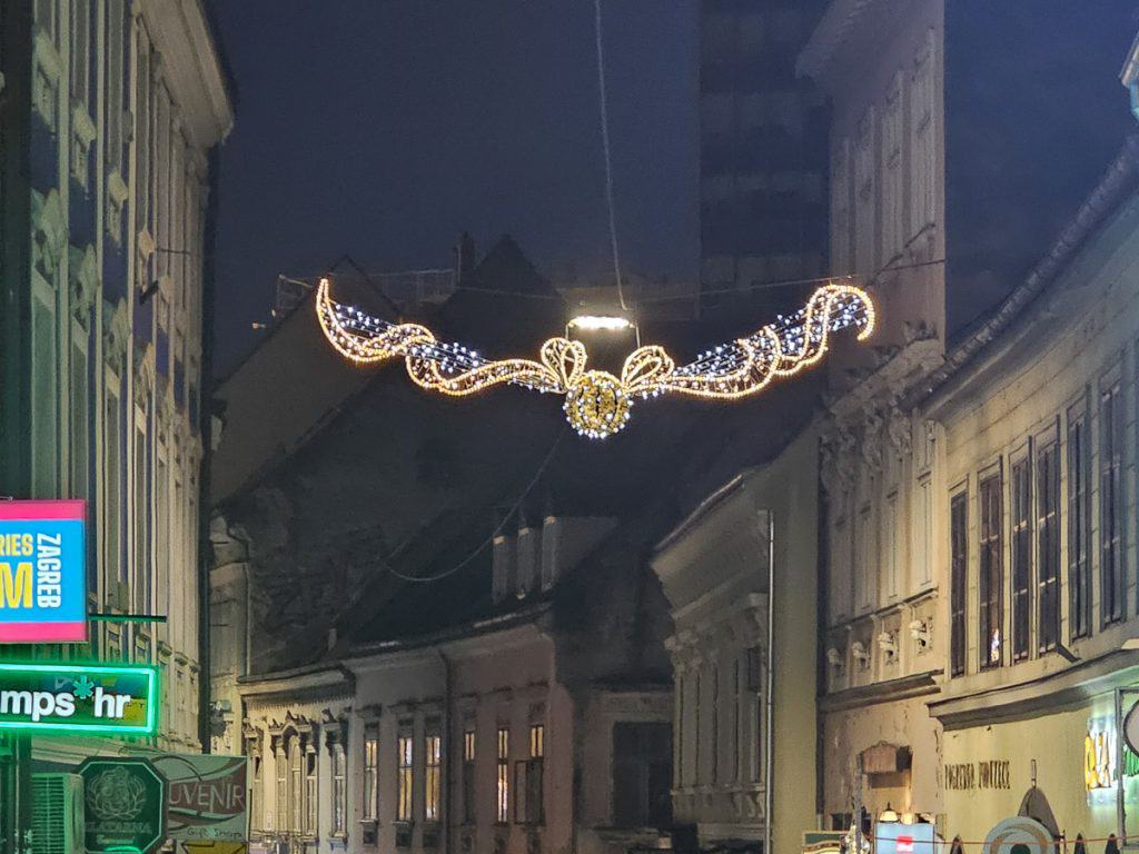 A small golden snitch light that is hung up on the side of the buildings.