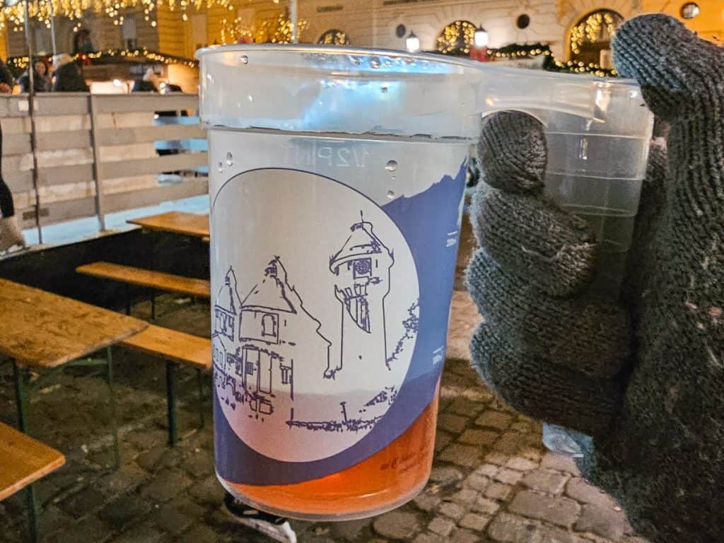 A clear cup with a blue image showing the Budapest castle.