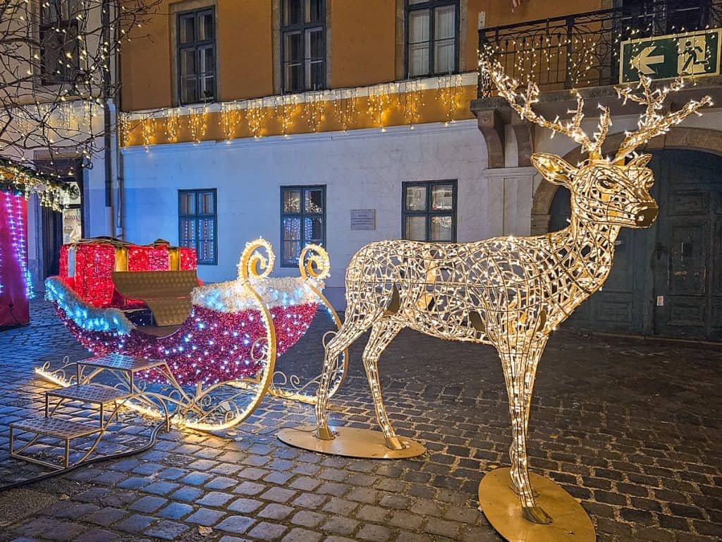 A lighted reindeer and sleigh with red presents.