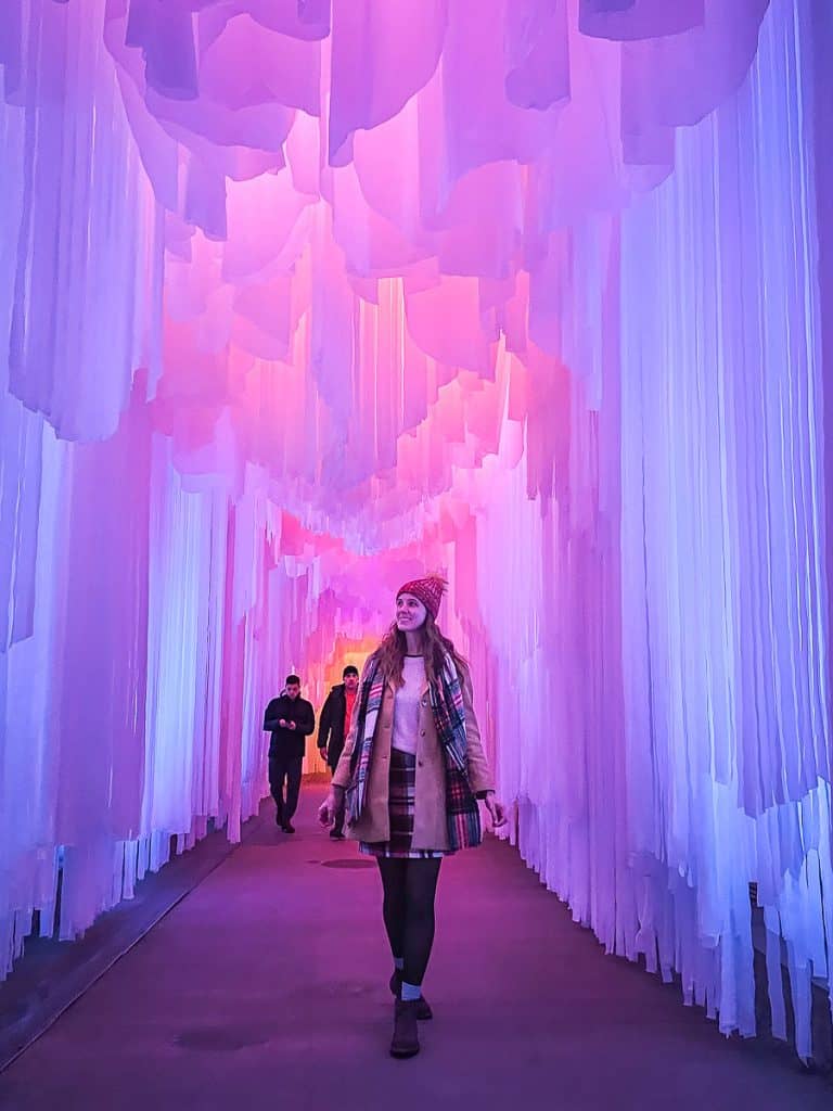 An ice palace with sheets of ice coming down to the ground and lights inside the ice creating an ombre effect.